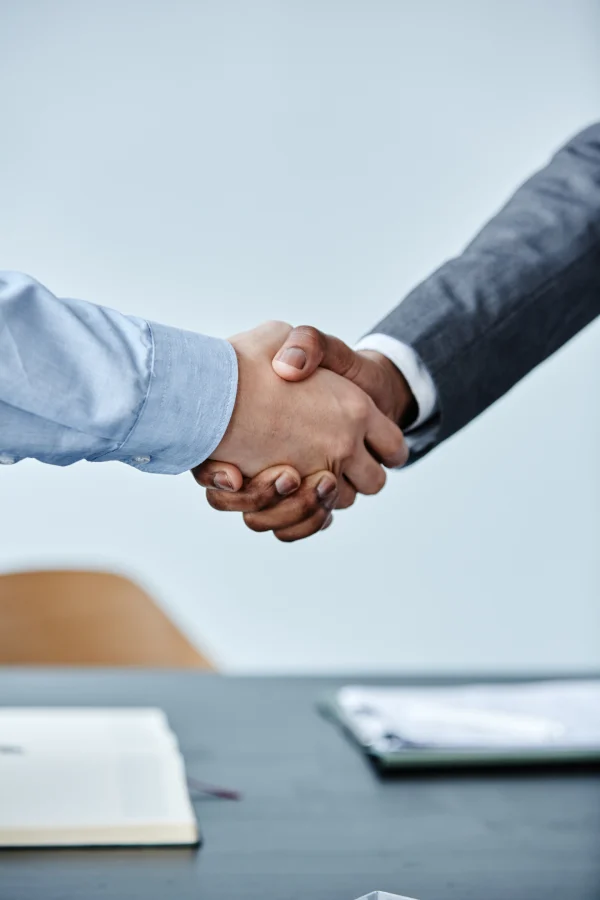 Aperto de mãos sobre uma mesa de reunião, representando o pilar de governança do ESG da Agropecuária Laffranchi